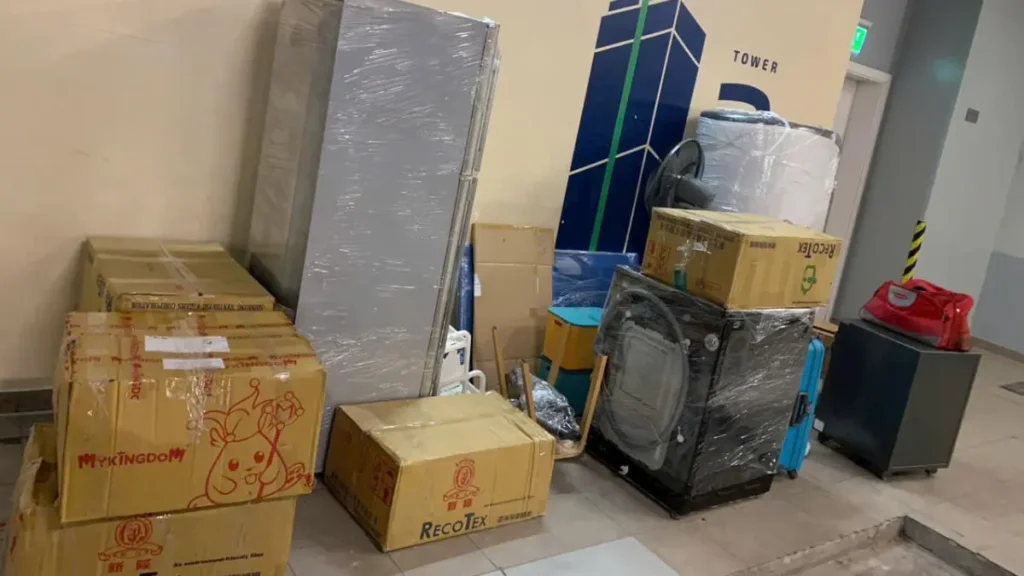 Hình ảnh thực tế đồ gia dụng, máy giặt, tủ lạnh và thùng carton được đóng gói, tập kết để bốc xếp chuyển nhà tại chung cư.